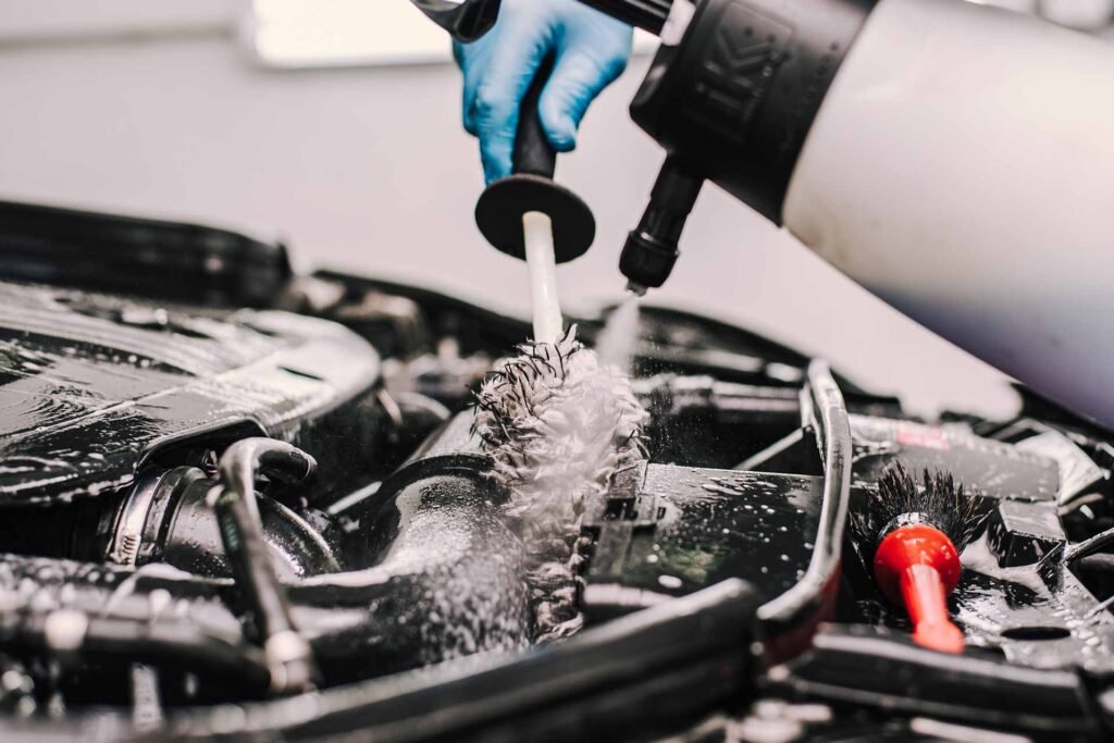 AutoShine technician wearing gloves while cleaning a vehicle’s engine bay during a mobile detailing service in Chicago
